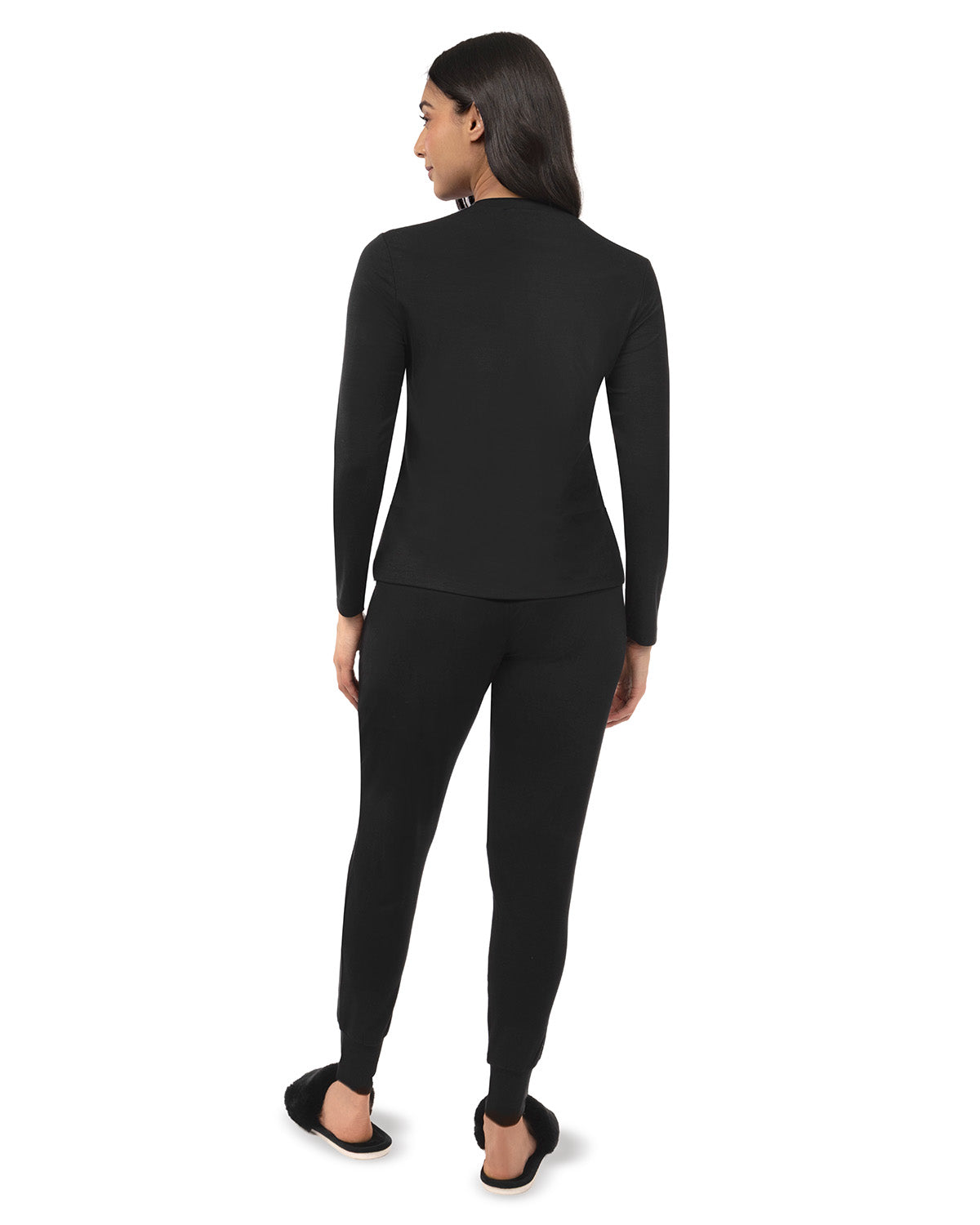 A woman shown from the back wearing a black long-sleeve mock neck top and matching black leggings, photographed against a plain white studio background.