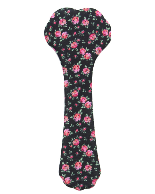 A bone-shaped dog toy or chew cover featuring a black background with a pink and red floral pattern and green leaves, shown on a plain white background.
