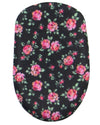 An oval-shaped fabric item, likely a pouch or cover, featuring a black background with a dense pink and red floral pattern and green leaves.