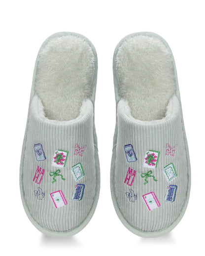 A pair of light gray ribbed slip-on slippers with a soft white fleece lining and colorful embroidered motifs including books, flowers, bows, and butterflies on the top.